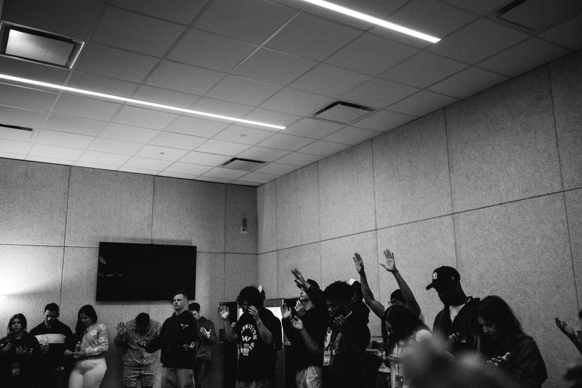 Black-and-white room wide with hands raised