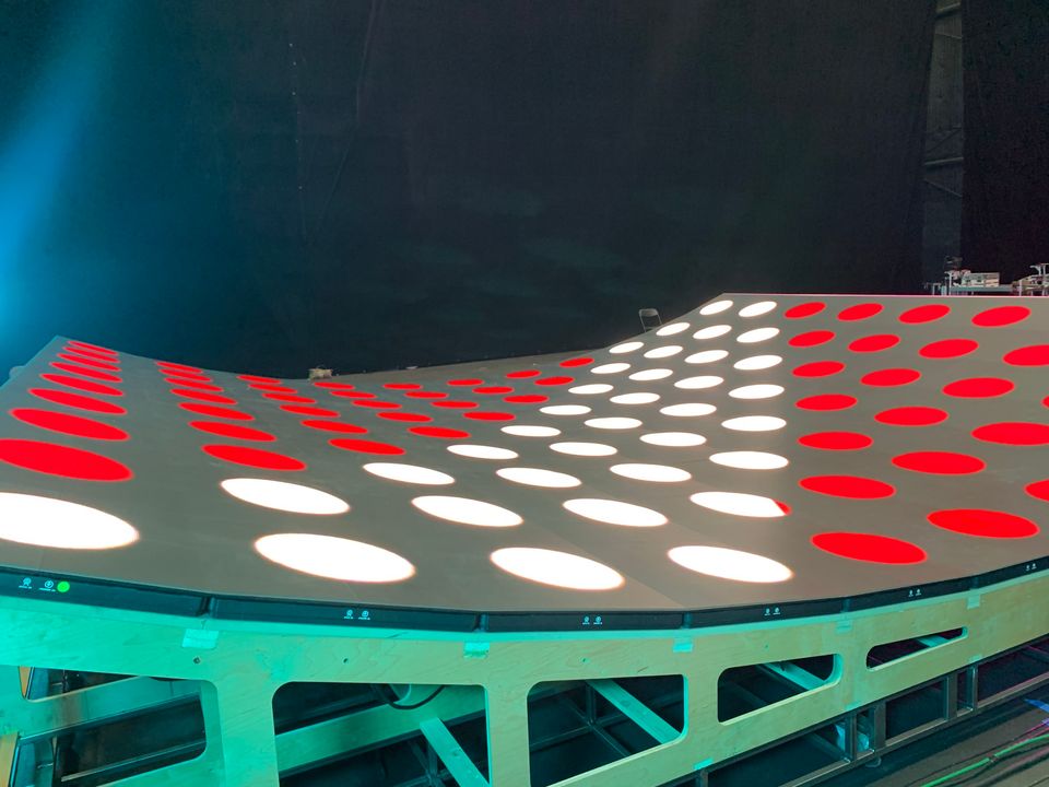 A dot pattern in red and white across the curved LED floor