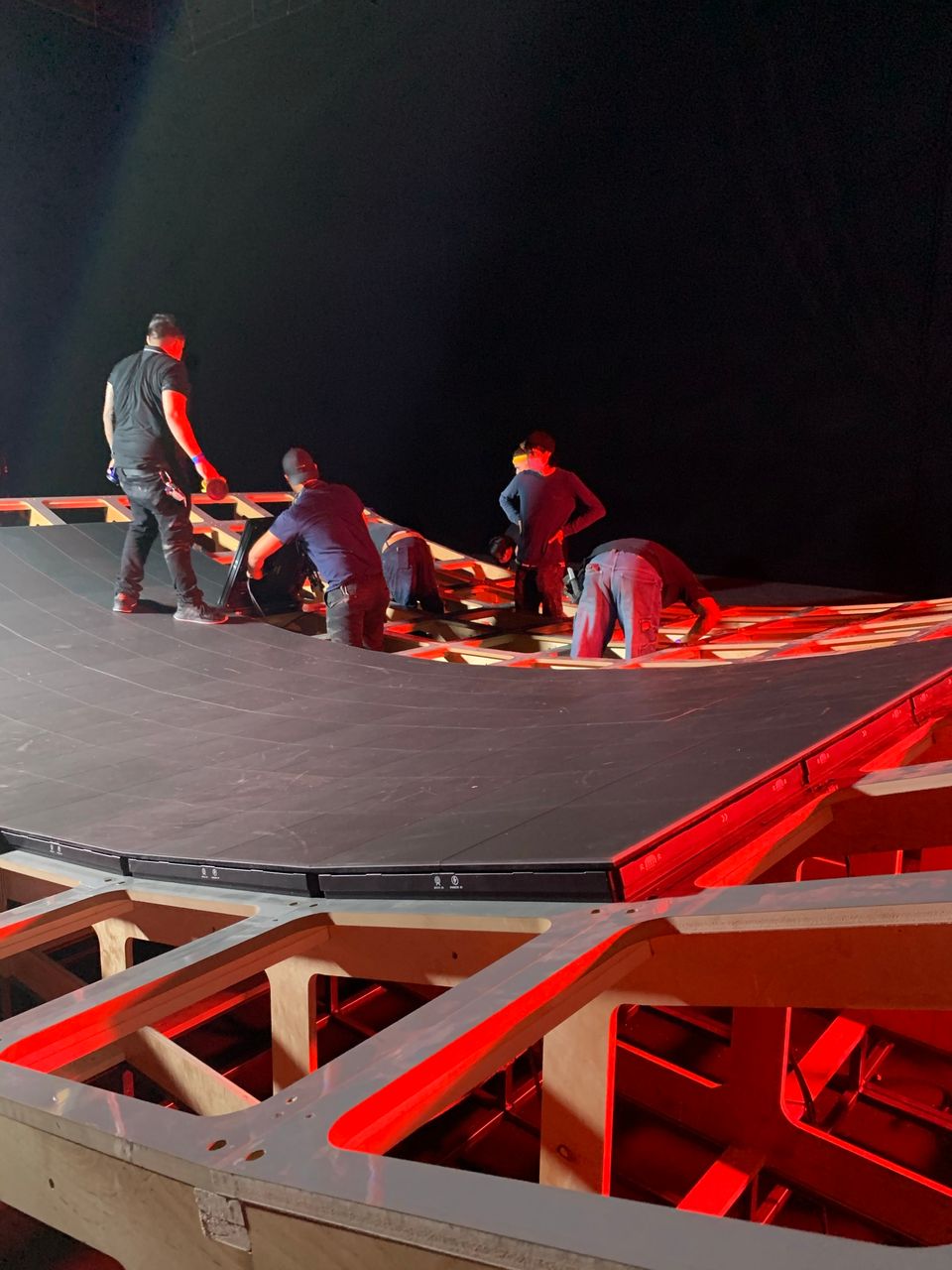 Crew laying LED tiles onto the curve under red light
