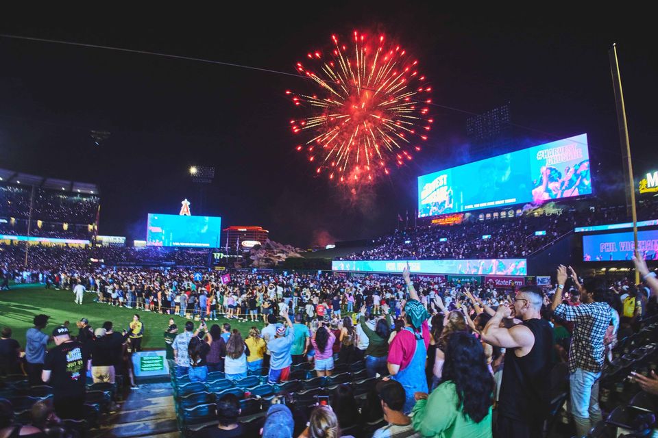 Fireworks over the crowd on the field with both outfield LED screens lit, Harvest Crusade 2024