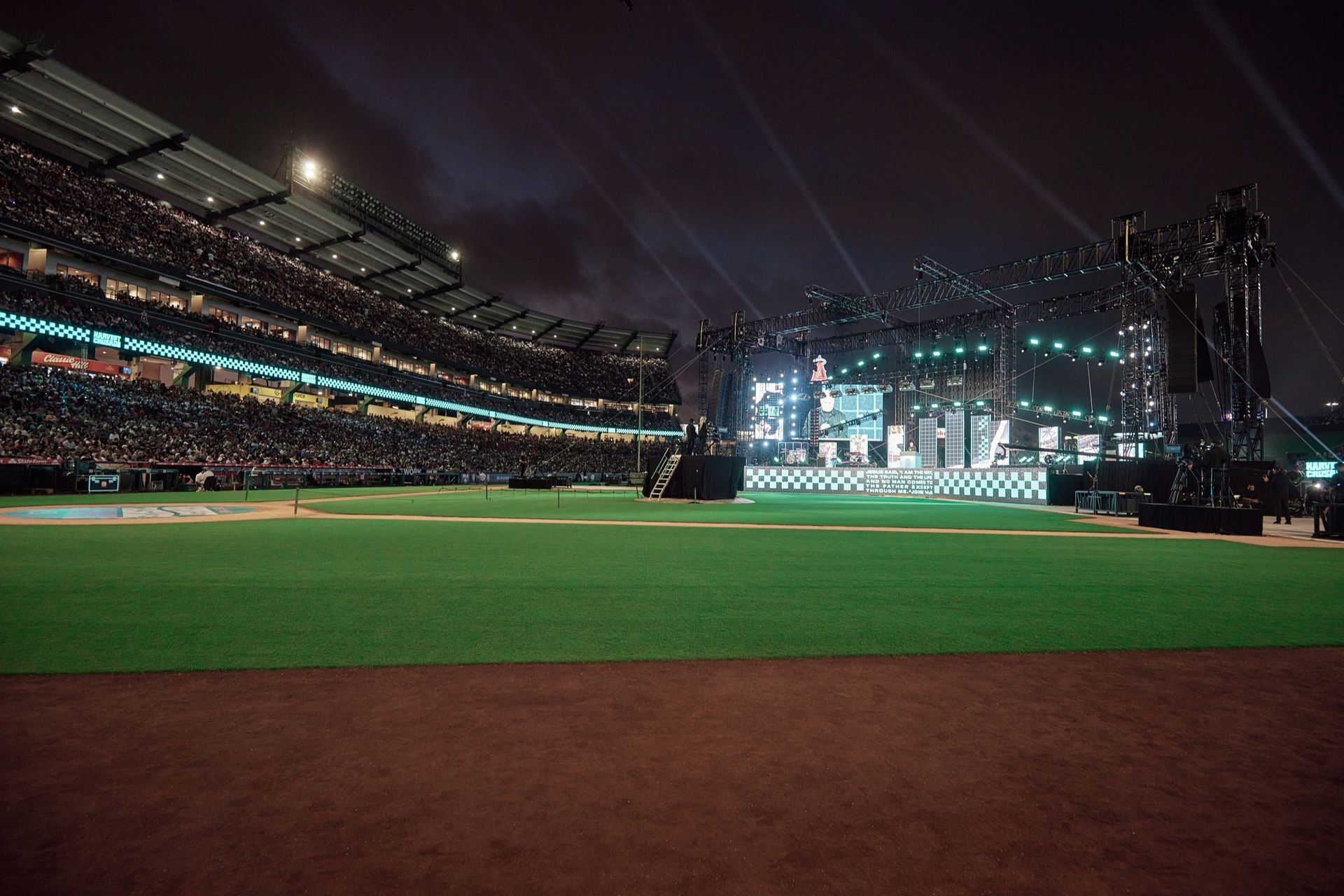 The stage and LED screens from the outfield grass before doors, Harvest Crusade 2025
