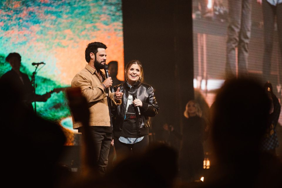 Two speakers on stage in front of an LED backdrop at Elevation Nights, Hershey