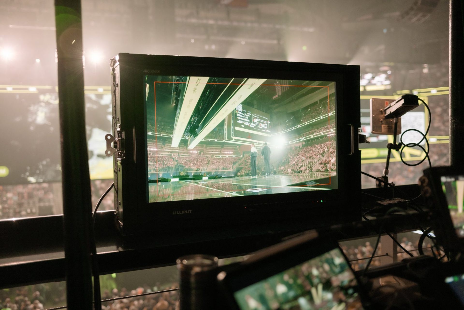 A director's monitor at front of house with the arena behind it