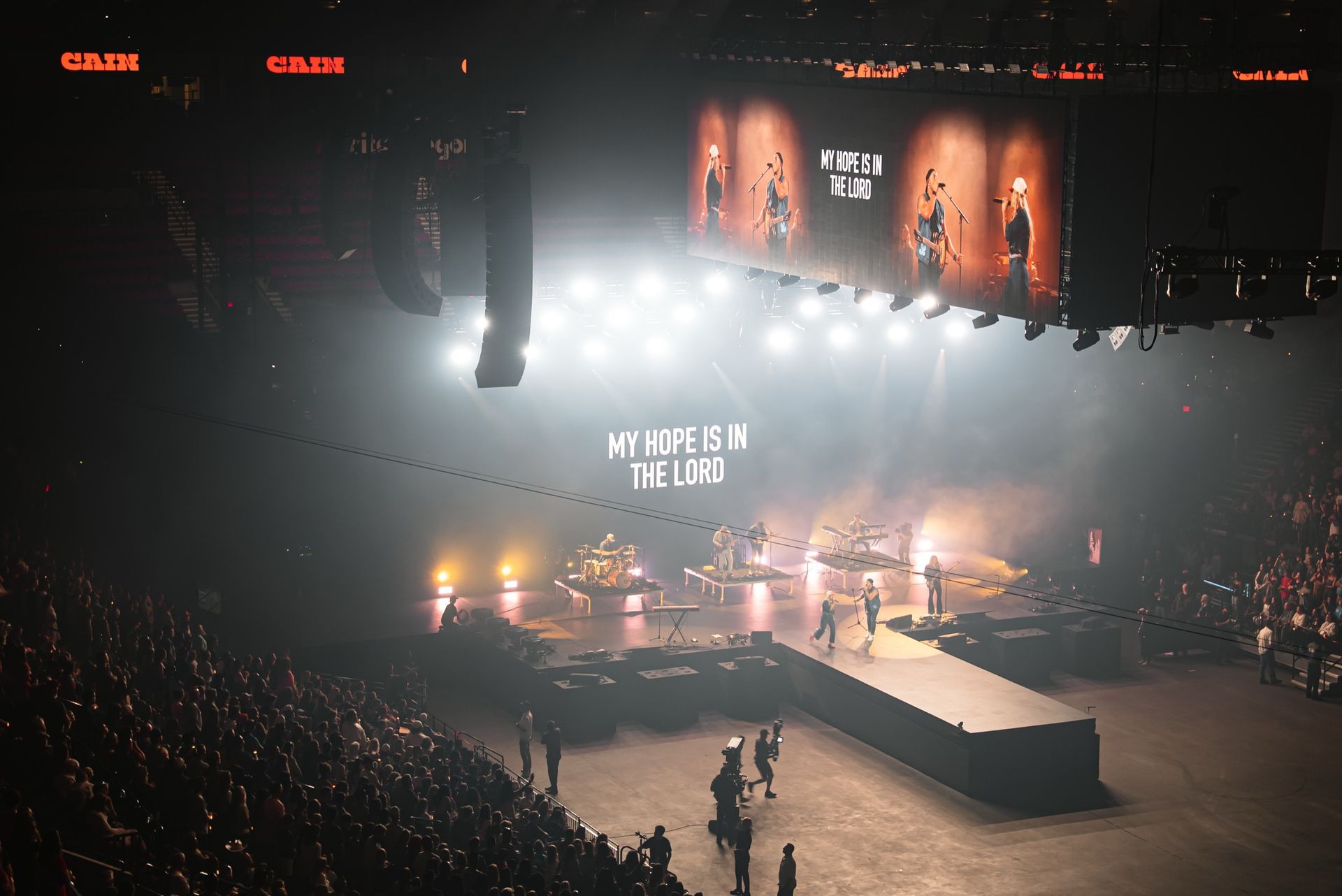 Stage wide with "My hope is in the Lord" across the upstage wall and the channel screens during CAIN