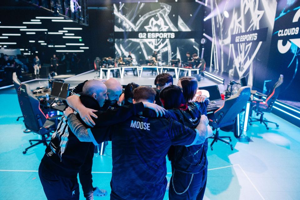 A team huddle on the LED floor before a match