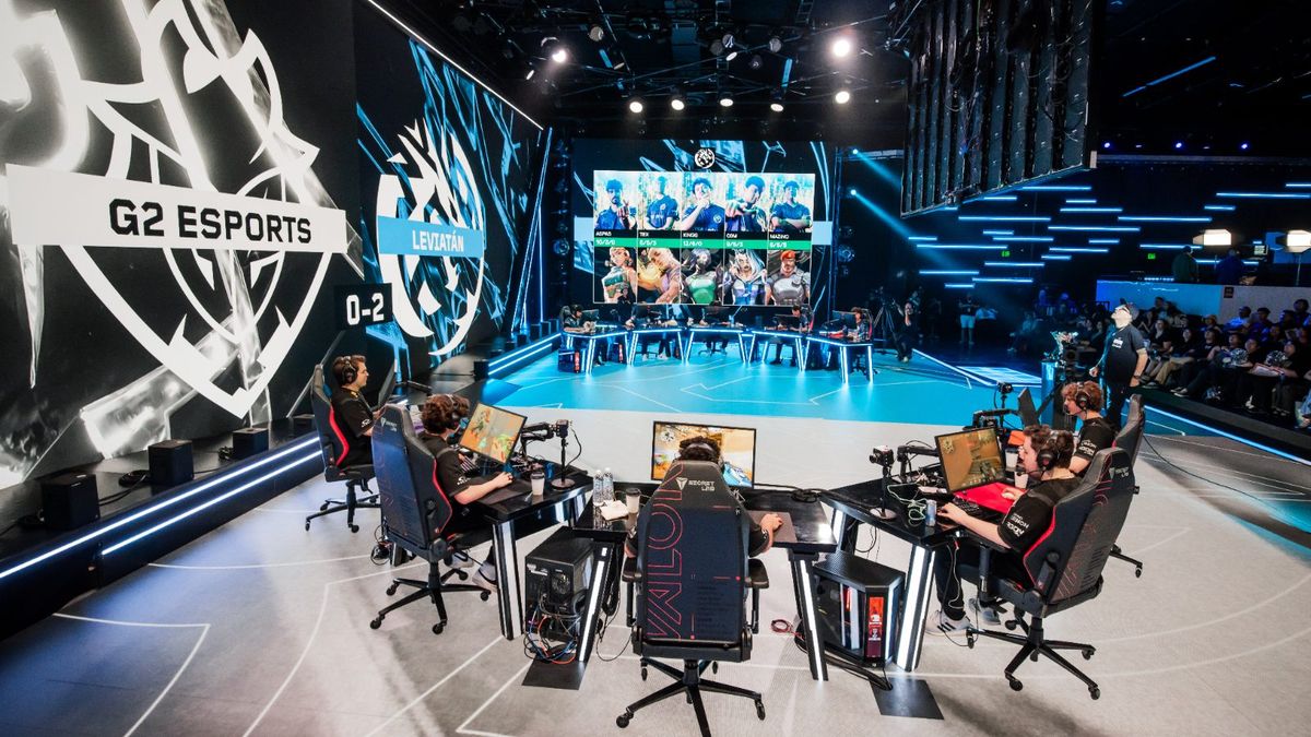 VCT stage at Riot Games Arena — players at their desks on the LED floor, team marks on the walls