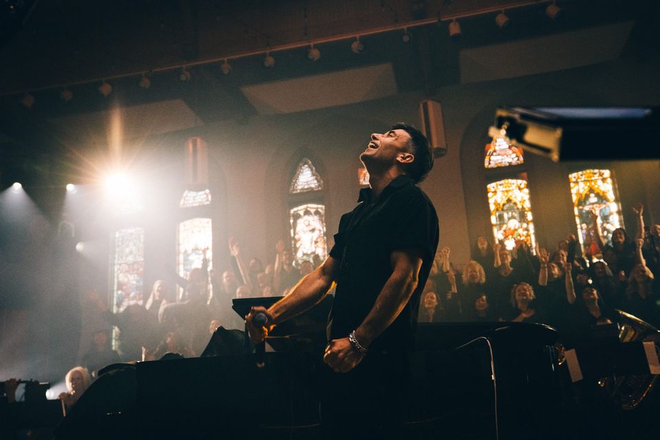 A singer under a single light during the Tommee Profitt live recording
