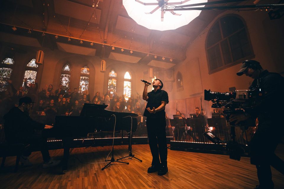 Camera operator at the edge of the stage during a live recording