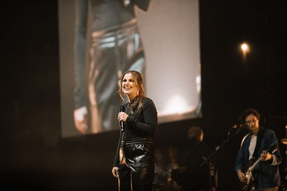 A worship leader with her own IMAG on the LED surface behind her