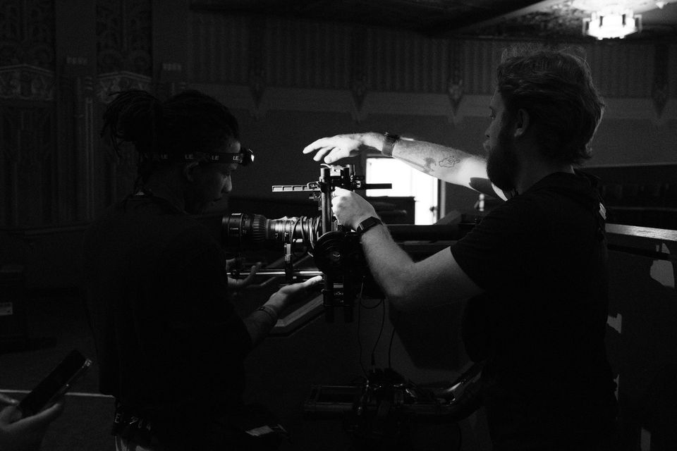 Two crew building a camera position in the theatre