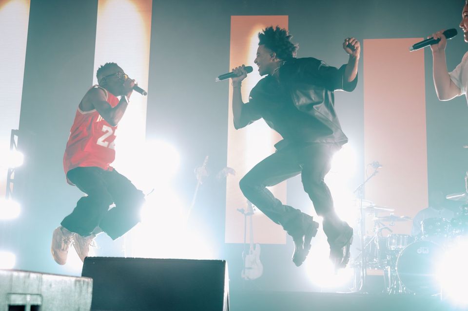 Two performers mid-jump in front of LED columns at Elevation YTH